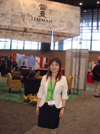 Grace Lee in front of Lehman, Lee & Xu booth.