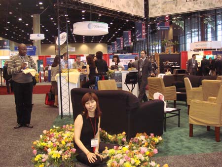 Linda Zhao in front of Lehman, Lee & Xu booth.