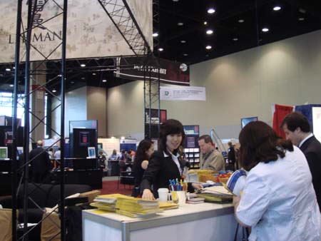 Sherry Wang assists visitors to the Lehman, Lee & Xu booth.
